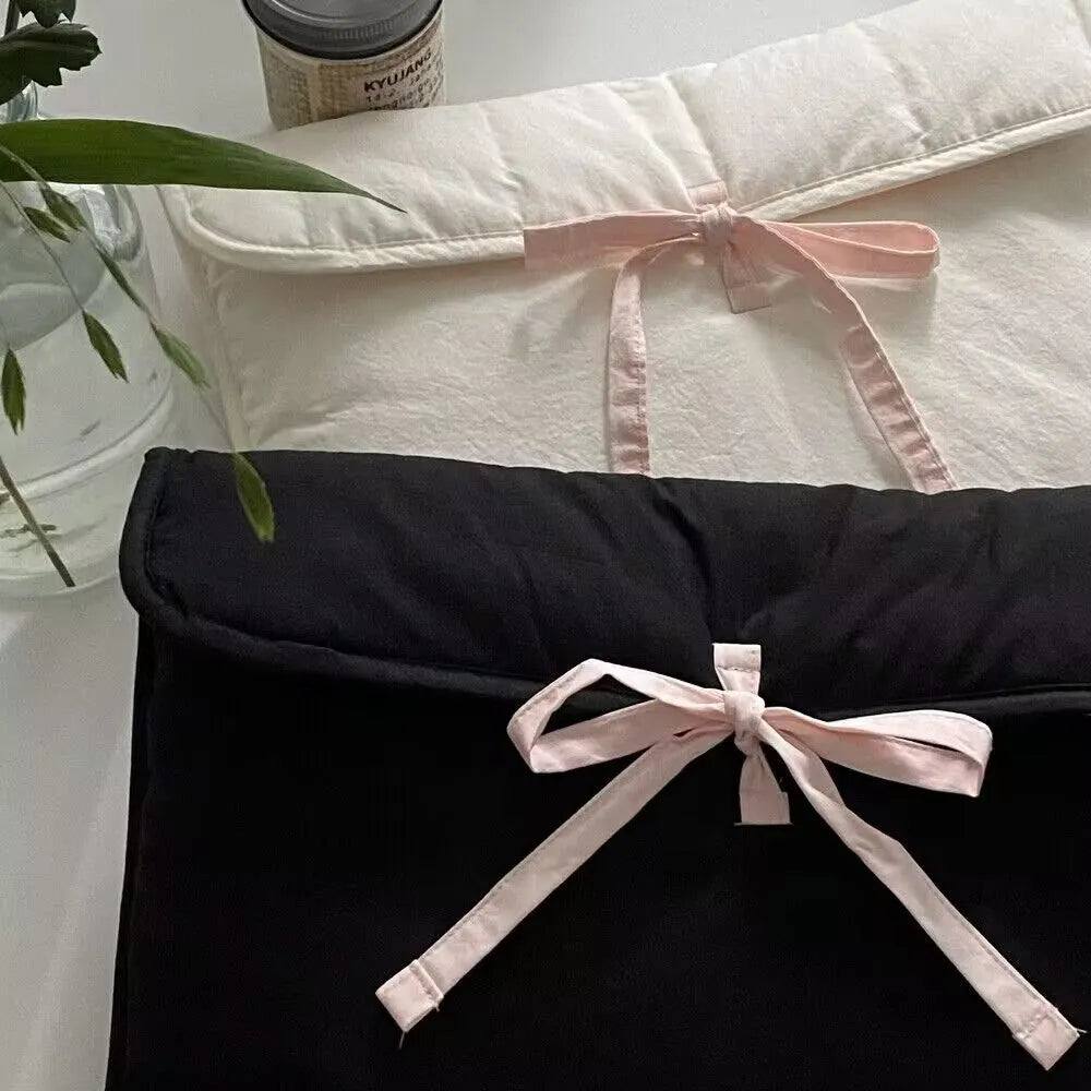 Black and white quilted women's laptop bag with striped pattern and ballet bow detail.