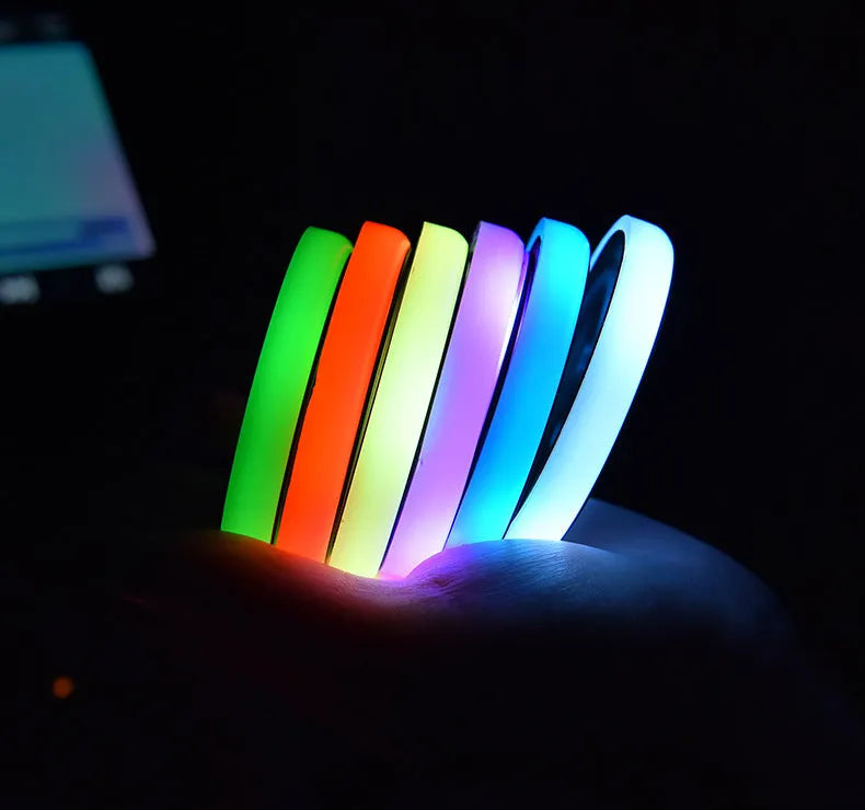 Colourful LED light-up coaster for car cup holder with USB cable on a car console.