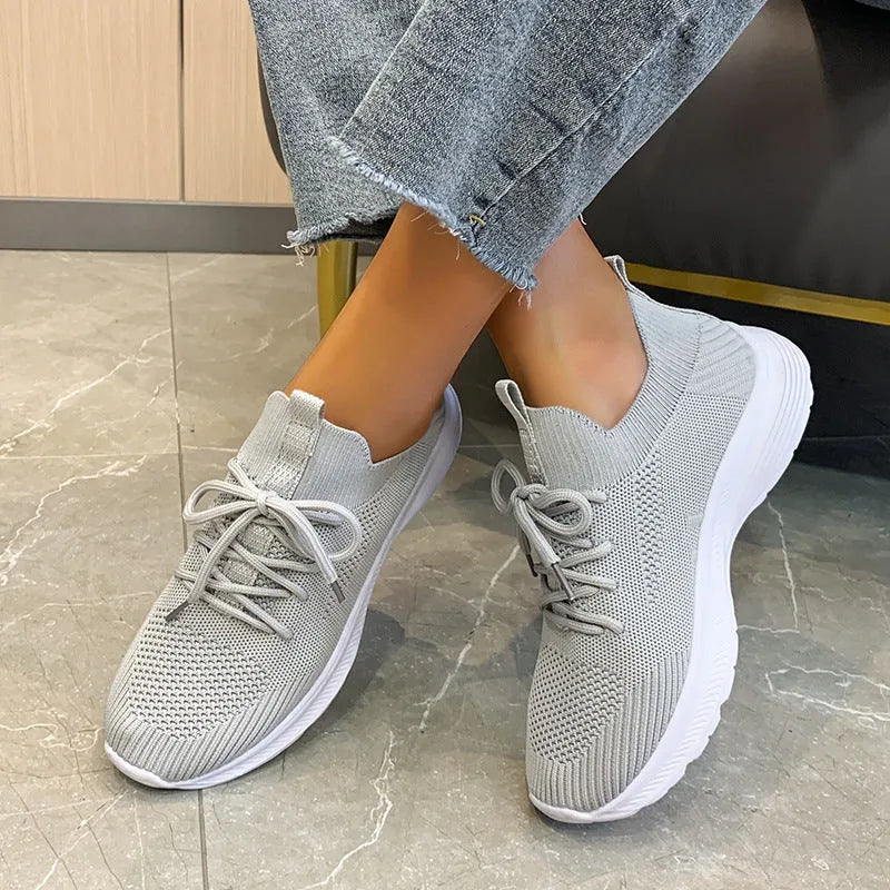 Women's low-top running shoes in creamy white with Flyknit upper and lace-up closure