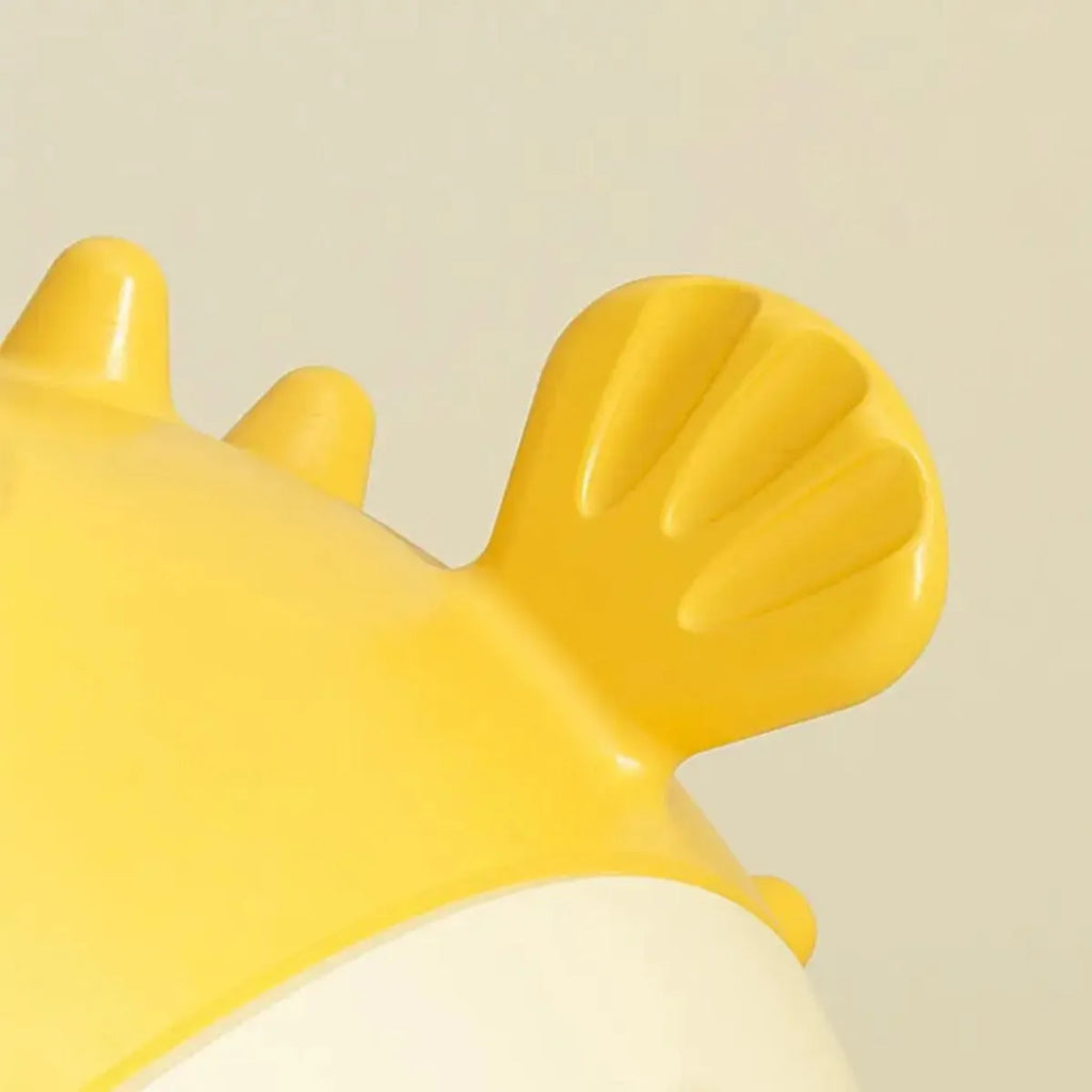 Yellow fish-shaped vinyl dog chew toy with textured surface and squeaker