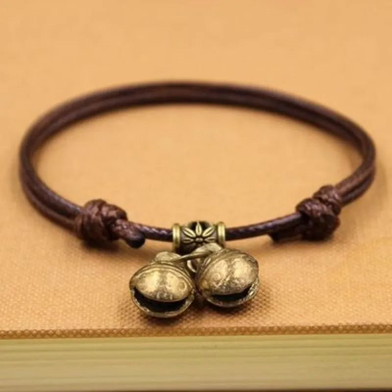 Small dog collar made of nylon rope with a brass bell, shown in black colour.