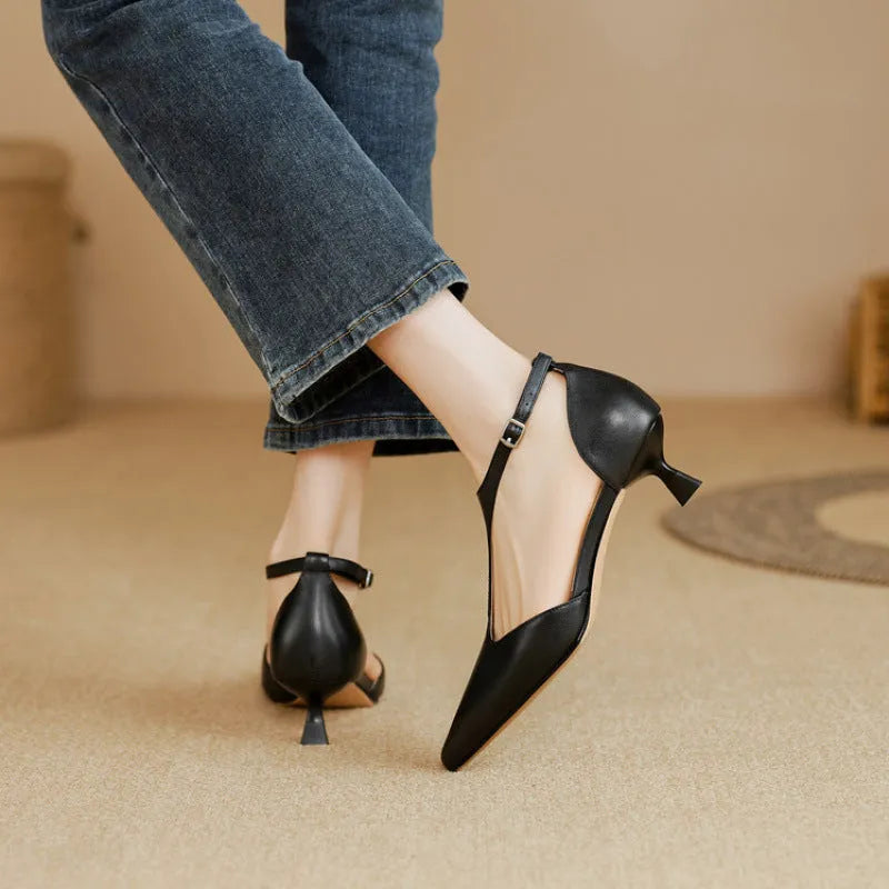 Women's brown and black cowhide high heels with a pointed toe on a white background.