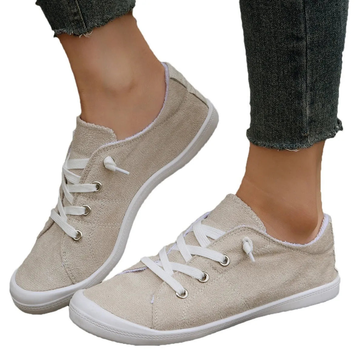 Women's low-top creamy white fabric sneakers with a wear-resistant rubber sole on a neutral background.