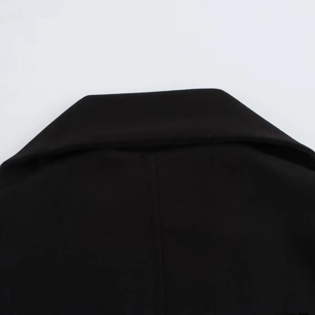 Women's long black coat with a detachable grey artificial fur collar, showing longline silhouette and side pockets.