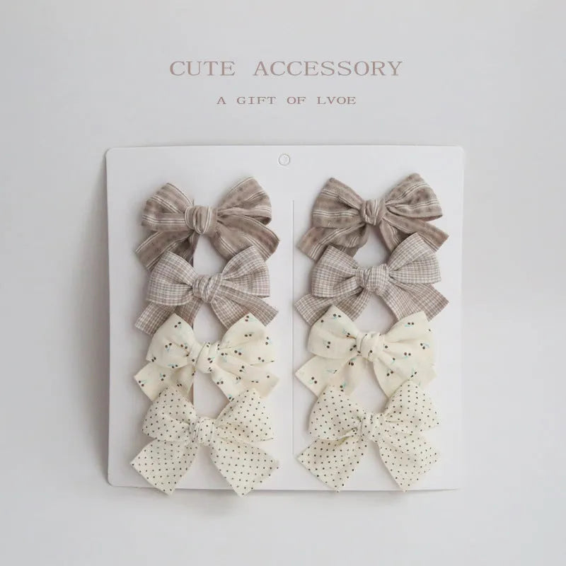 Set of eight fabric dovetail bow hairclips for children in various colours