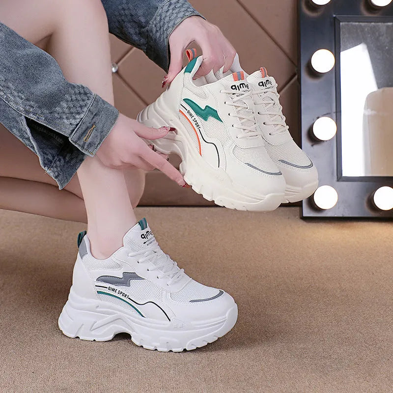 Women's white height increasing dad shoes with cross straps and lace-up front on rubber sole.