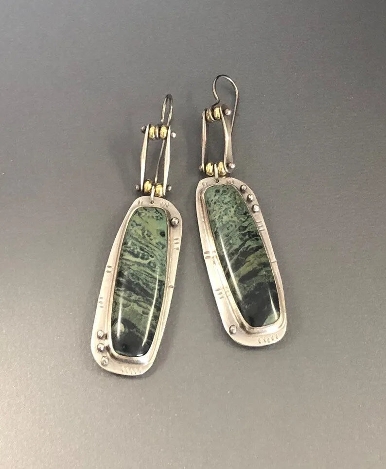 Geometric shaped drop earrings with a black and white marble pattern on an alloy metal backdrop.