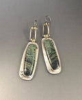 Geometric shaped drop earrings with a black and white marble pattern on an alloy metal backdrop.