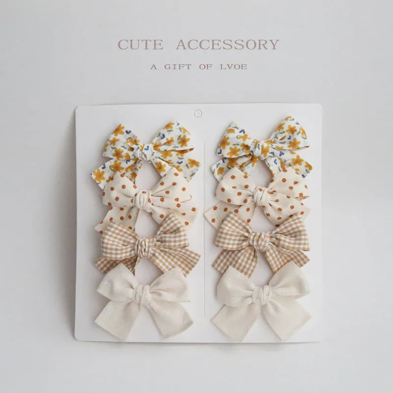 Set of eight fabric dovetail bow hairclips for children in various colours