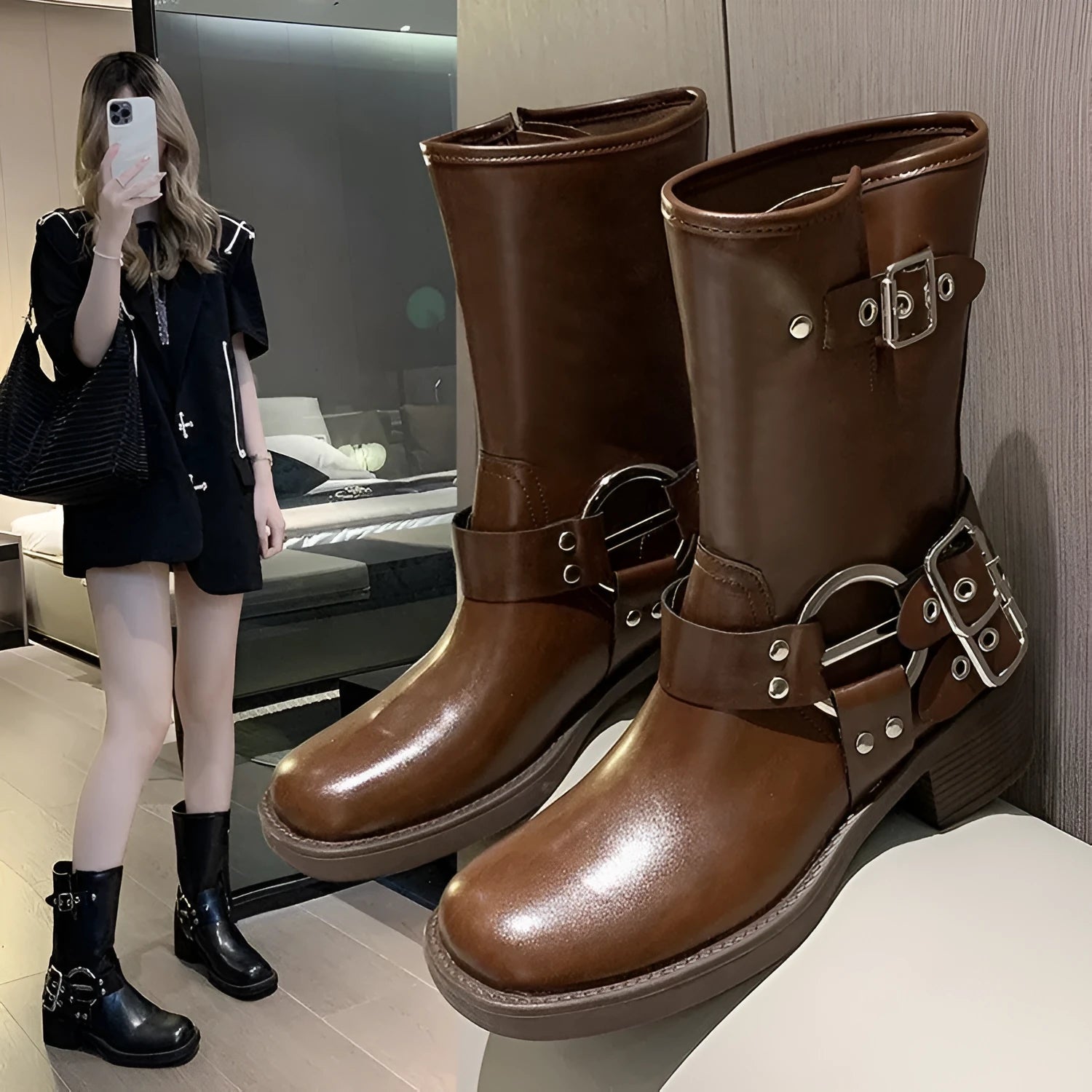 Women's black leather platform boots with belt buckle detail at mid-calf height