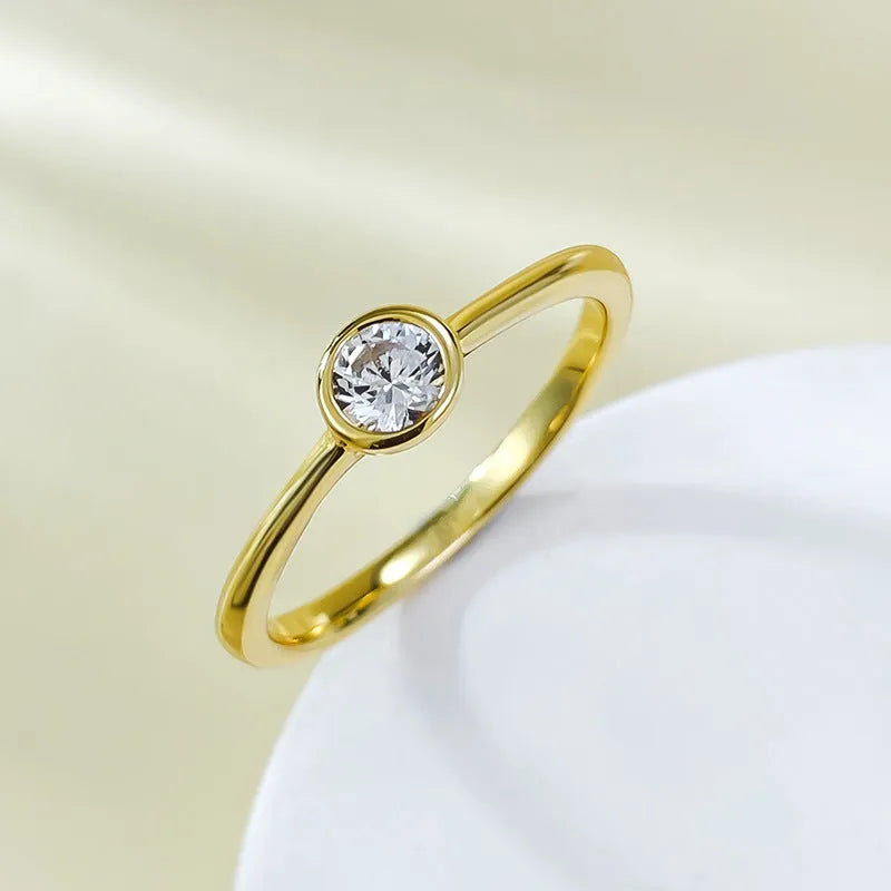 Minimalist crown shape silver ring electroplated in gold or platinum colour on a plain background.
