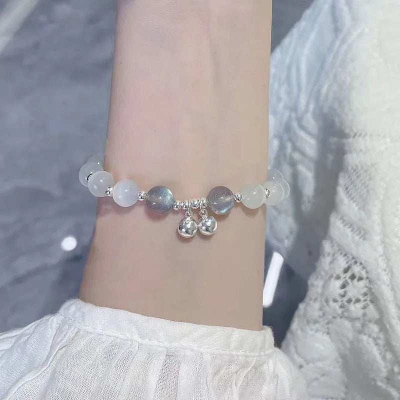 A Chinese style glass bracelet with bamboo leaf and bead designs on a wrist.