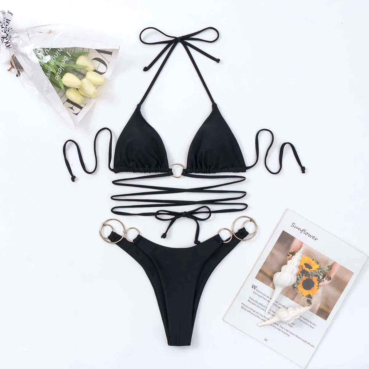 Black women's bikini set with metal ring details and long connecting straps, backless top and split bottom.