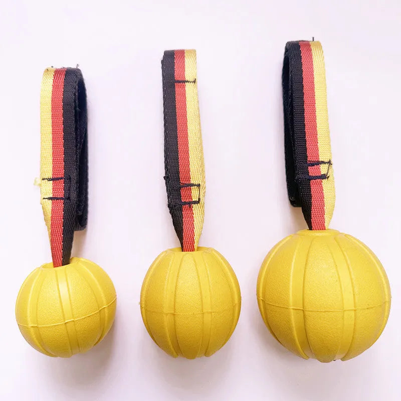 Yellow EVA floating dog ball with string attached, next to a camouflage coloured version on a blue background.