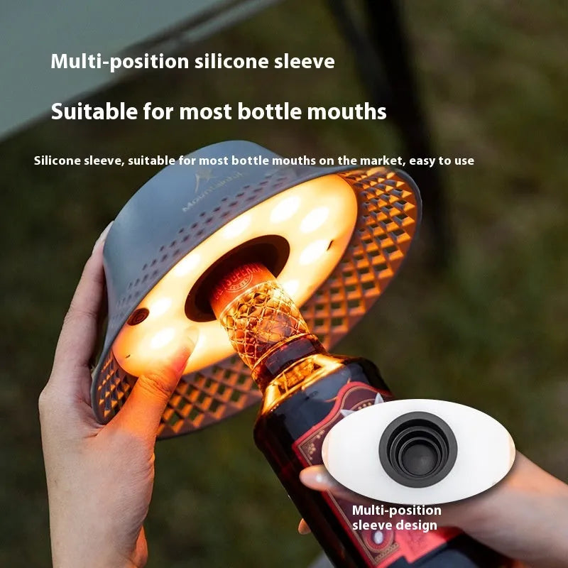 Beige and grey camping lantern with wine bottle-shaped shade showing USB-C port and light modes.