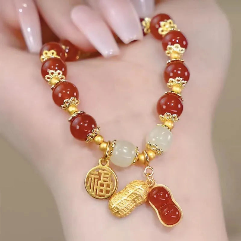 A Chinese style glass bracelet with bamboo leaf and bead designs on a wrist.