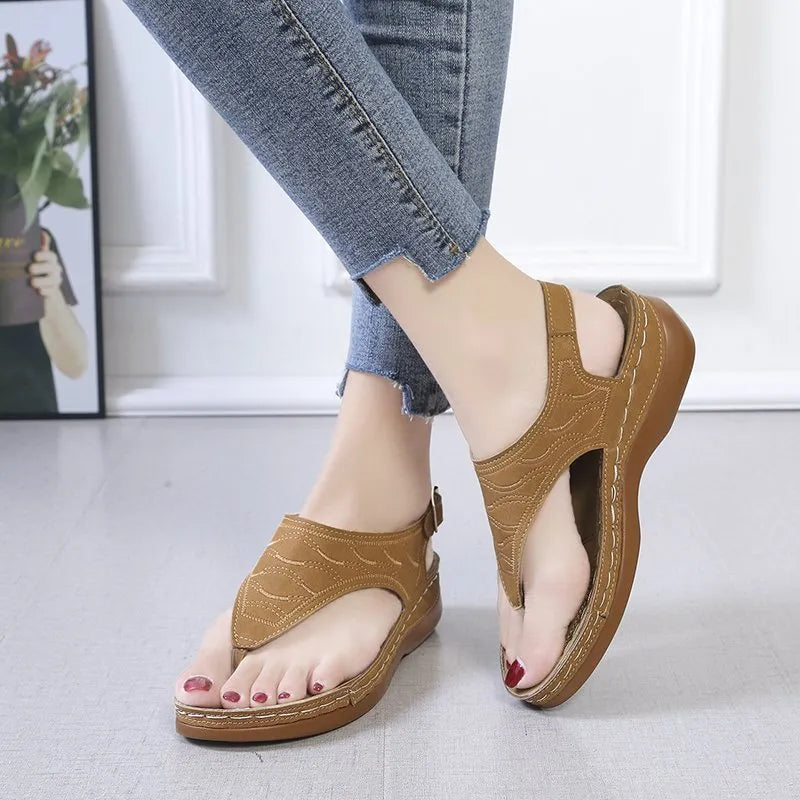Women's wedge heel flip flop sandals in black with an adjustable back strap and buckle.