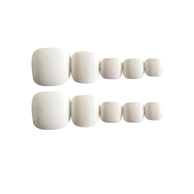 White artificial toenails with a starry sky pattern and adhesive.
