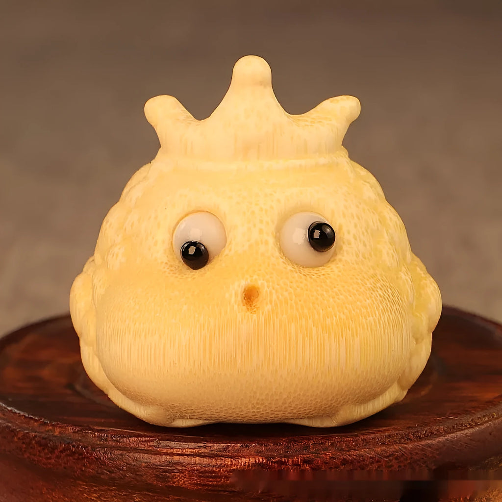 Close-up of a hand-carved bamboo Crown Princess toad ornament with live eye detailing.