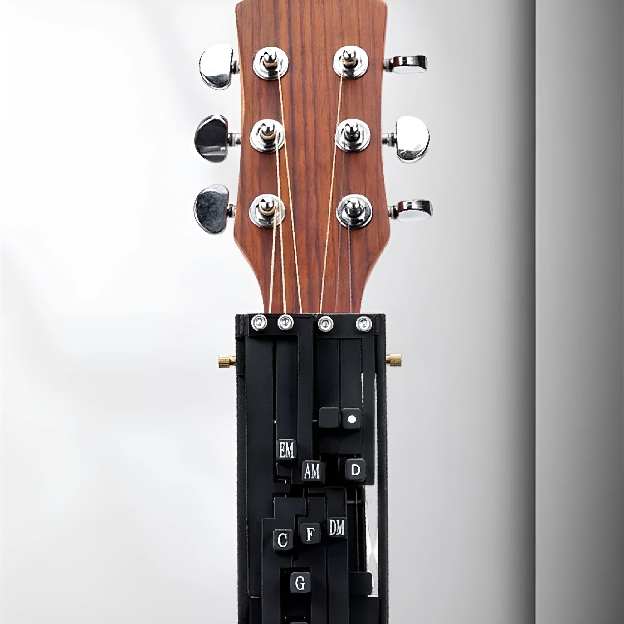 Black automatic chord changing device mounted on folk guitar neck for novice practice