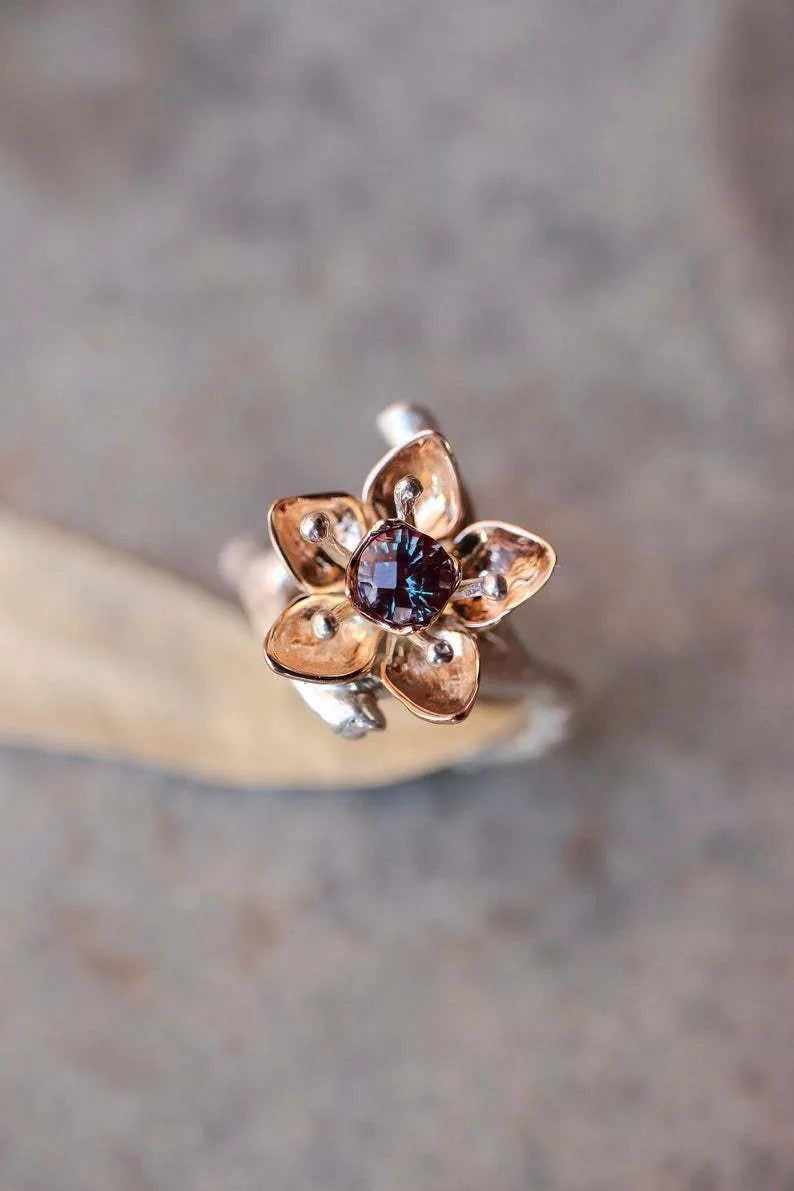 Silver two-tone women's floral ring with a simple geometric shape on a neutral background.