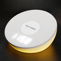 White wireless smartphone charger with digital clock display and three control buttons on the front.