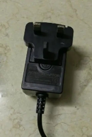 Charging cordless hair clippers with stainless steel cutter head on a stand, with UK, US and EU plug options.
