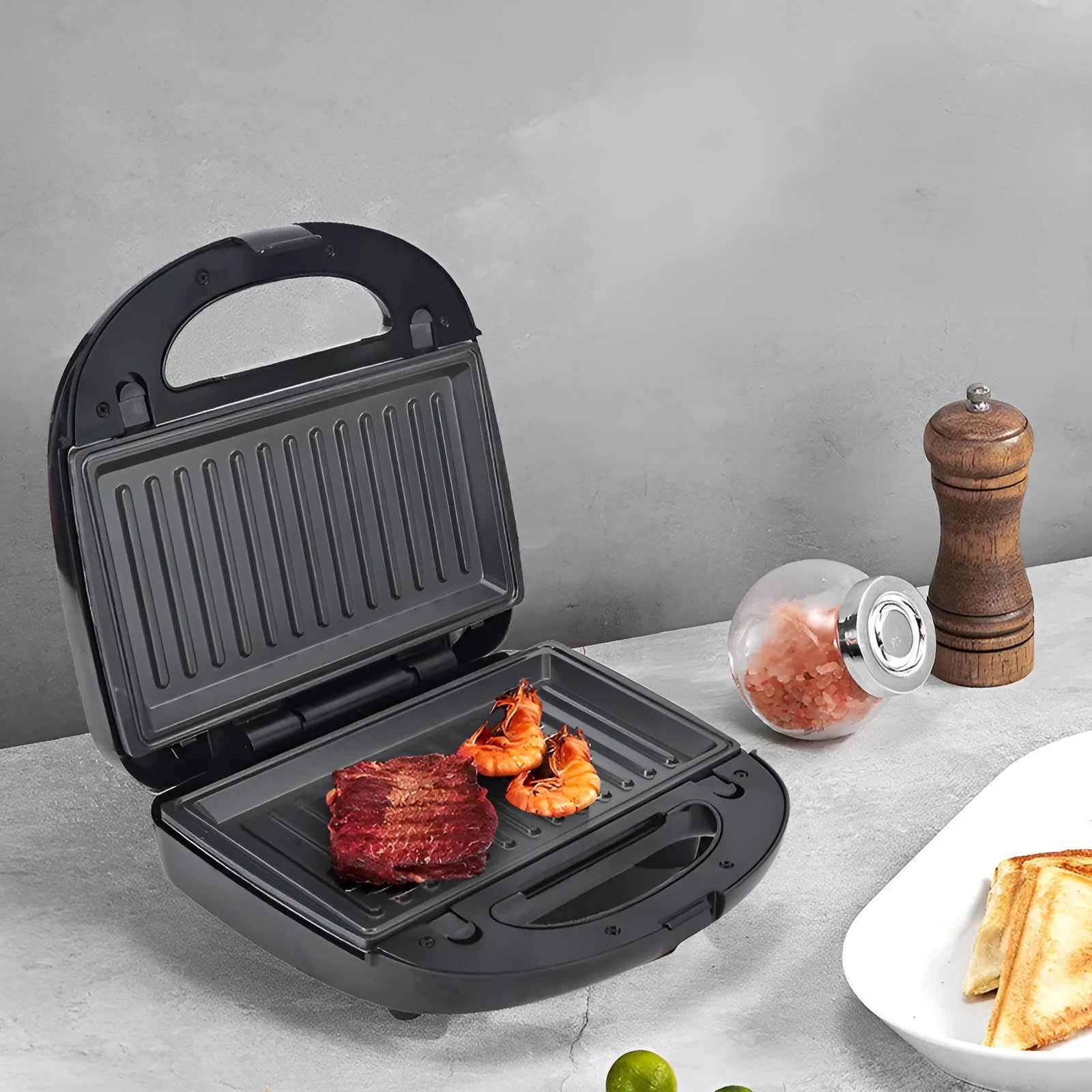 Black double-sided electric sandwich pan with six interchangeable non-stick plates and brushed stainless steel cover