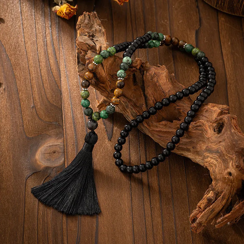 Bohemian-style long necklace chain with vintage tassel and matching bracelet on dark background
