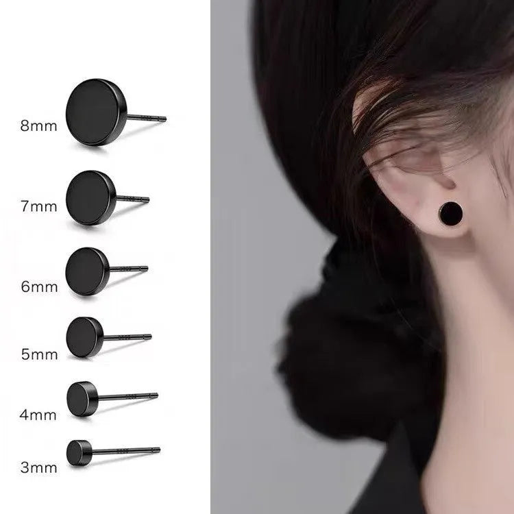 A pair of simple round sterling silver S999 stud earrings on a flat surface, shown in silver and black finishes.