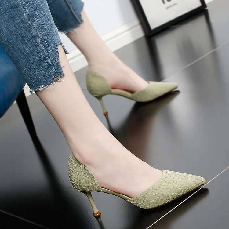Women's black pointed high heel shoes with stiletto heel on neutral background