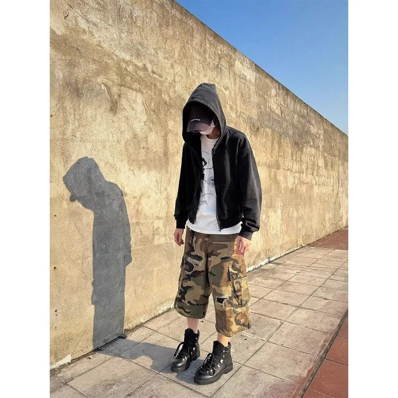 Men's camouflage-colour jeans with patch details, ripped fabric, and a cropped, loose straight-leg fit.