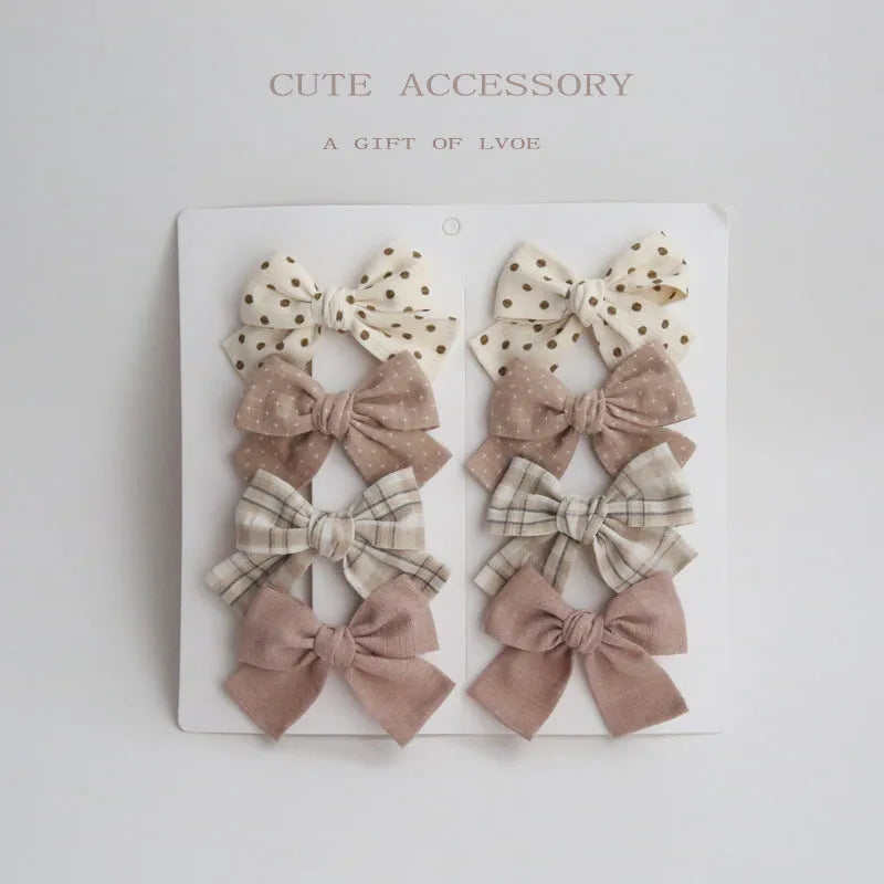 Set of eight fabric dovetail bow hairclips for children in various colours