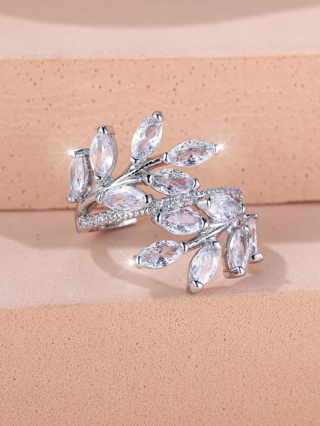 Adjustable opening copper leaf fashion ring with sparkling zirconia stones in a rose gold finish.