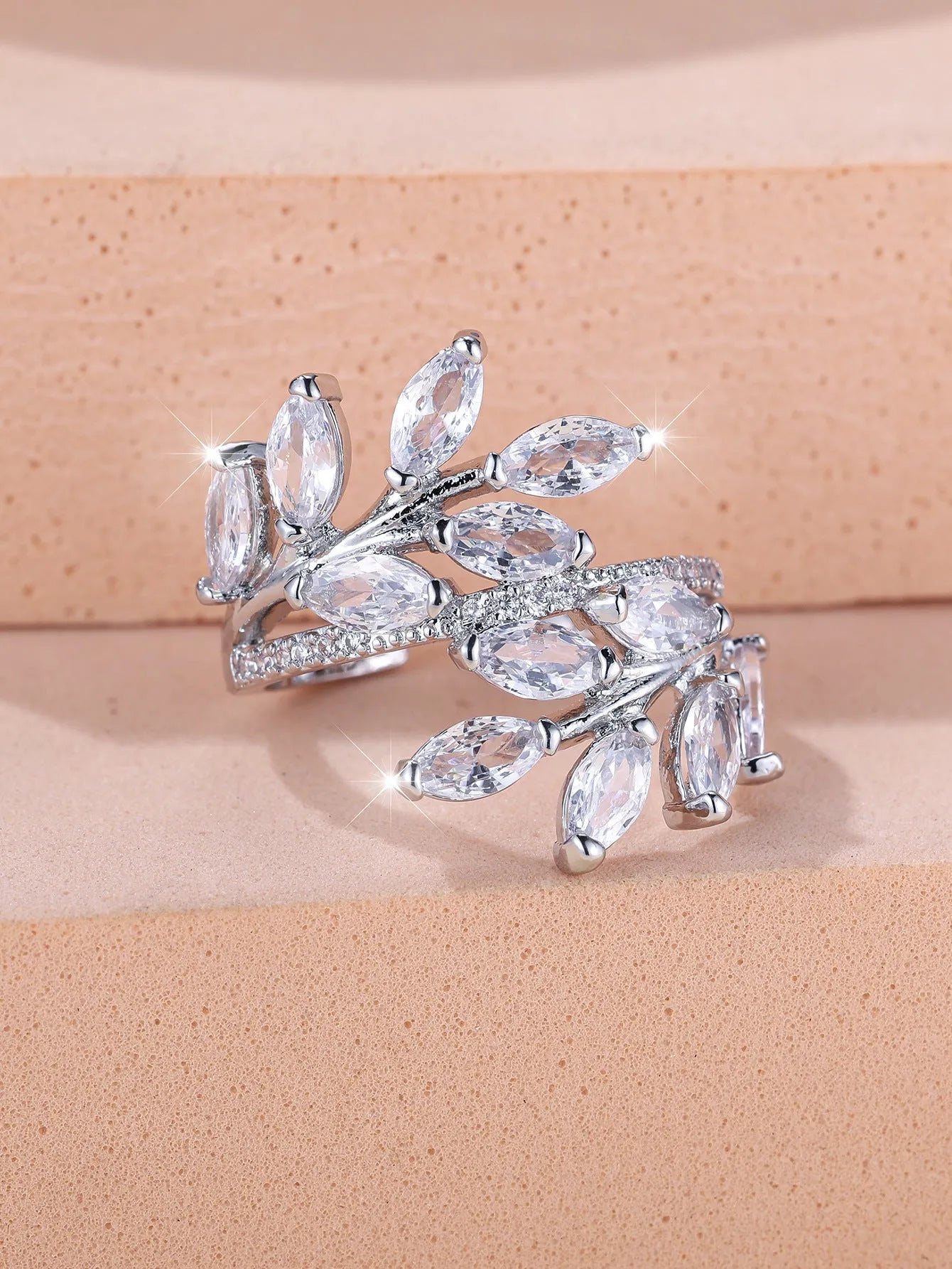 Adjustable opening copper leaf fashion ring with sparkling zirconia stones in a rose gold finish.