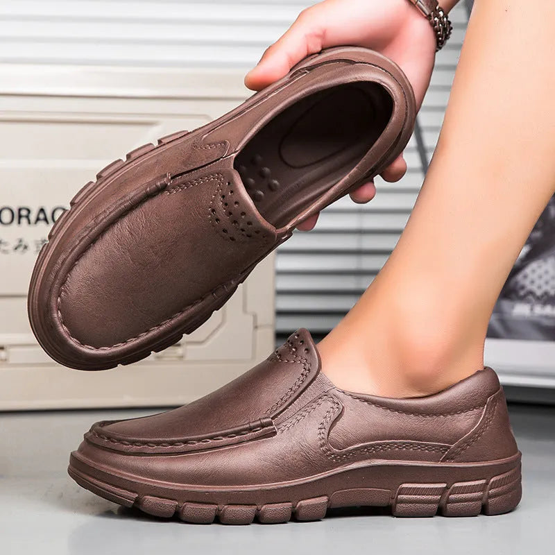 Men's black slip-on work shoes with a mid-top waterproof platform sole on a white background.