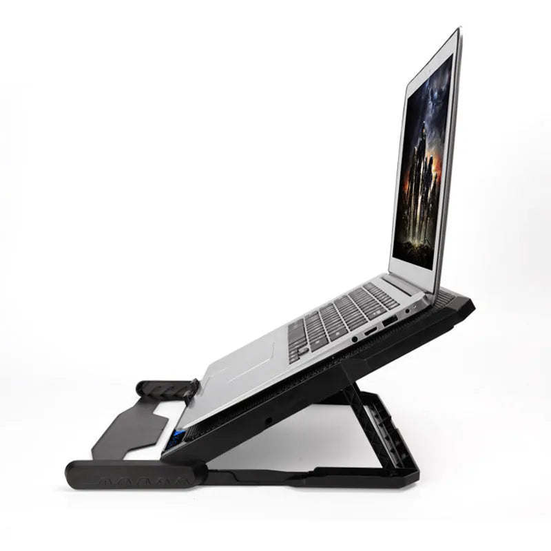 Black metal mesh laptop cooling board with a fan, placed under a notebook on a desk.