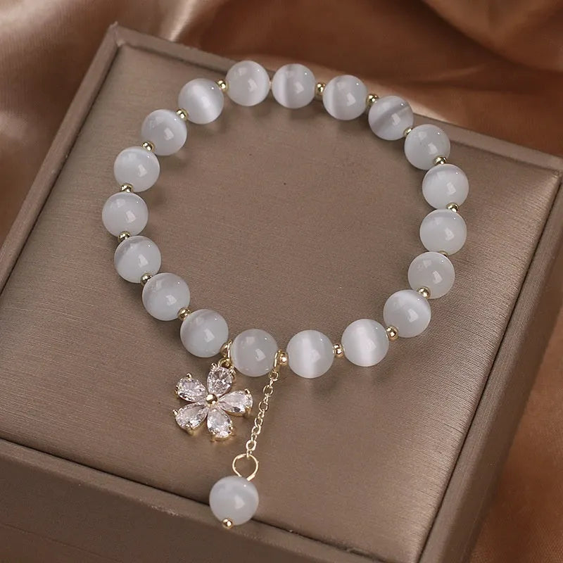 White cat's eye stone women's bracelet with flower tassel and morganite safety buckle pendant.