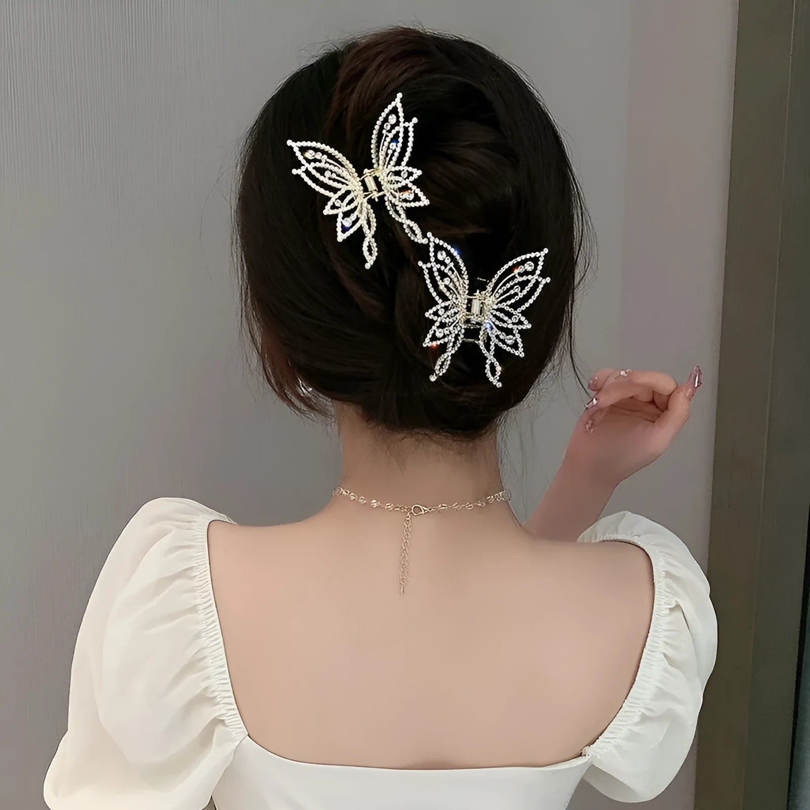 Butterfly-shaped alloy hair clip for women with electroplated finish, shown in rhinestone and pearl styles.