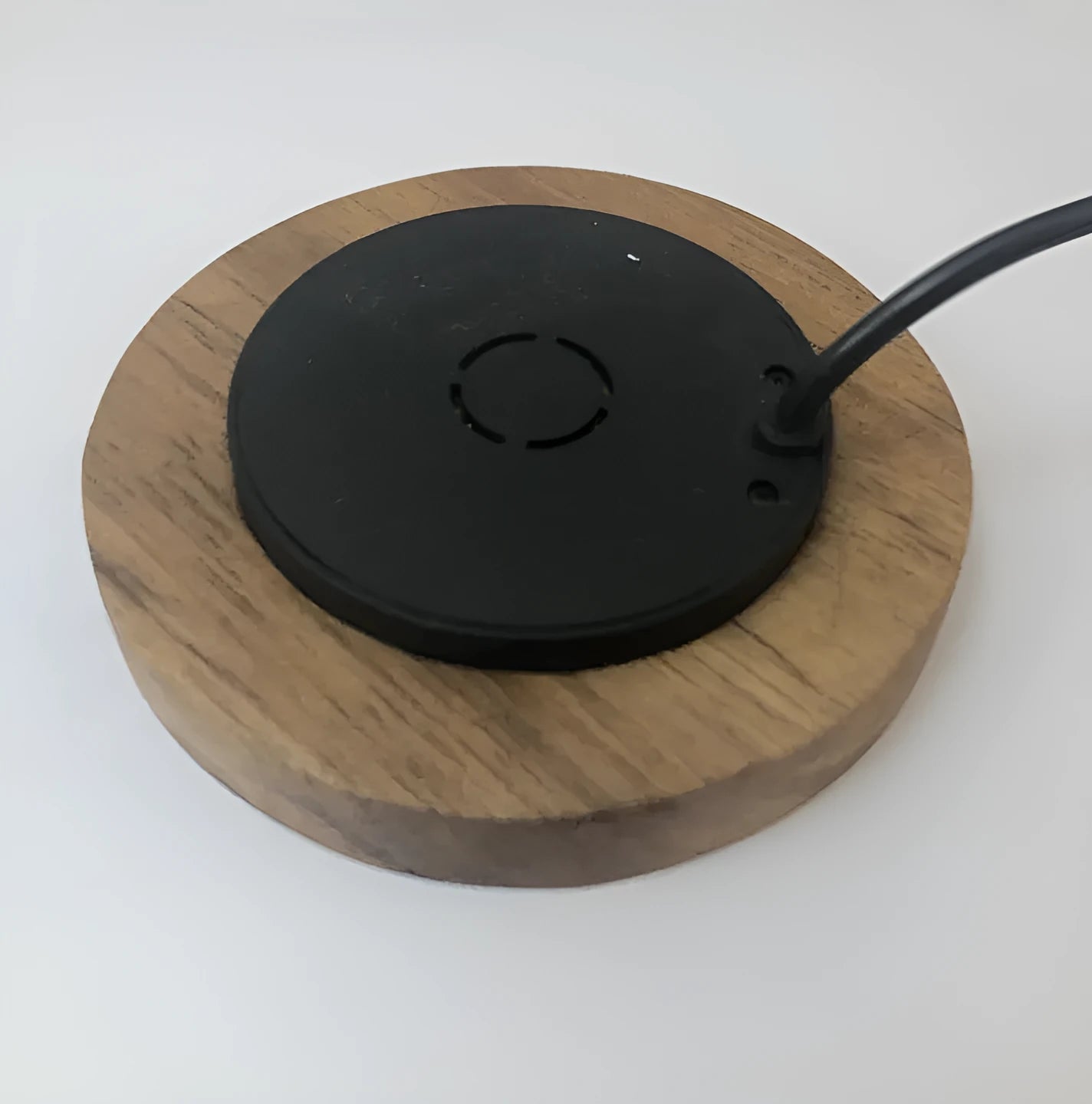 Round embedded wireless phone charger for installation in desks and furniture, shown with USB port.