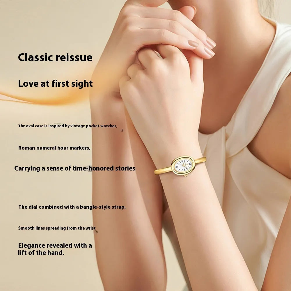 Women's oval retro quartz watch in gold colour with spiral pattern on dial.