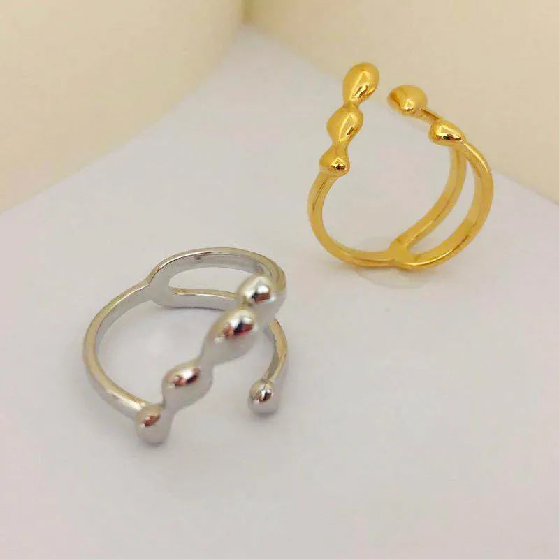 Brass adjustable fashion ring with spherical detail in gold or silver finish.