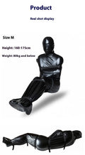 Black patent leather bondage clothing set with full body wrap and six ratchet tie-down straps
