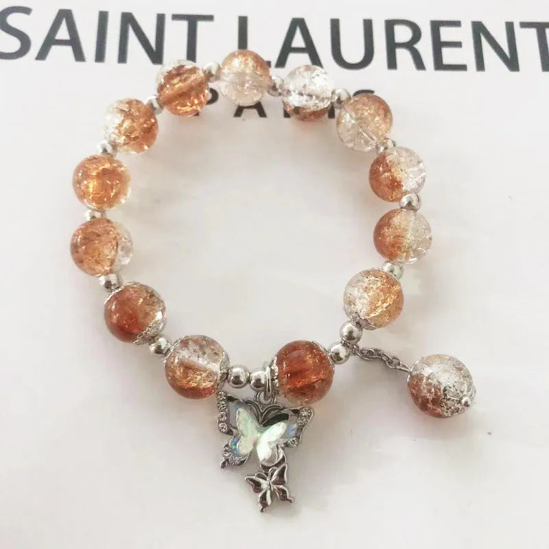 A Chinese style glass bracelet with bamboo leaf and bead designs on a wrist.