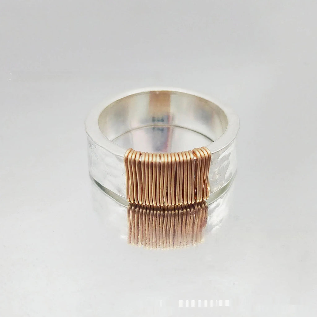 Geometric copper bracelet with irregular coil design and silver-gold electroplated finish.