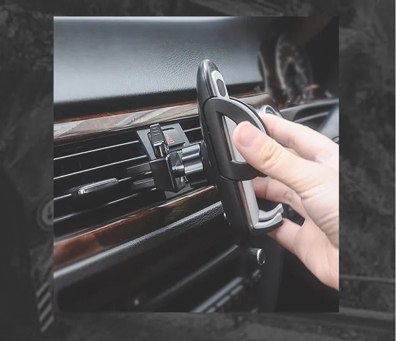 Black mobile phone holder clipped to car air conditioning vent with smartphone mounted