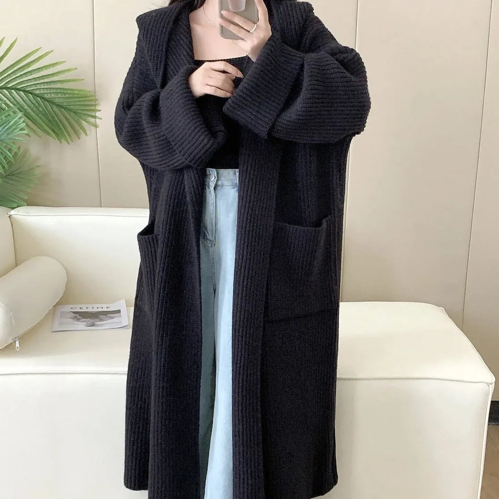 A woman wearing a longline milky white hooded cardigan sweatshirt with raglan sleeves.