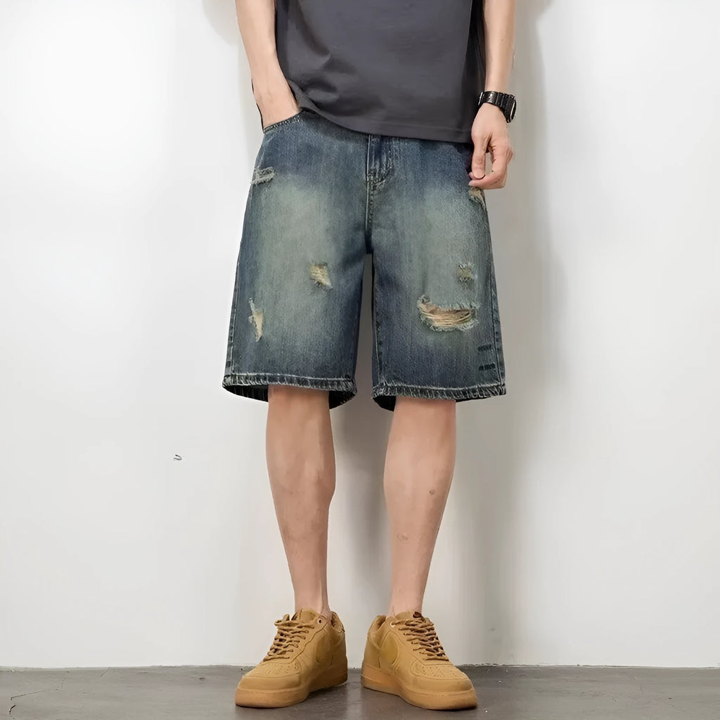 Retro blue denim men's shorts with distressed holes and straight leg cut on mannequin