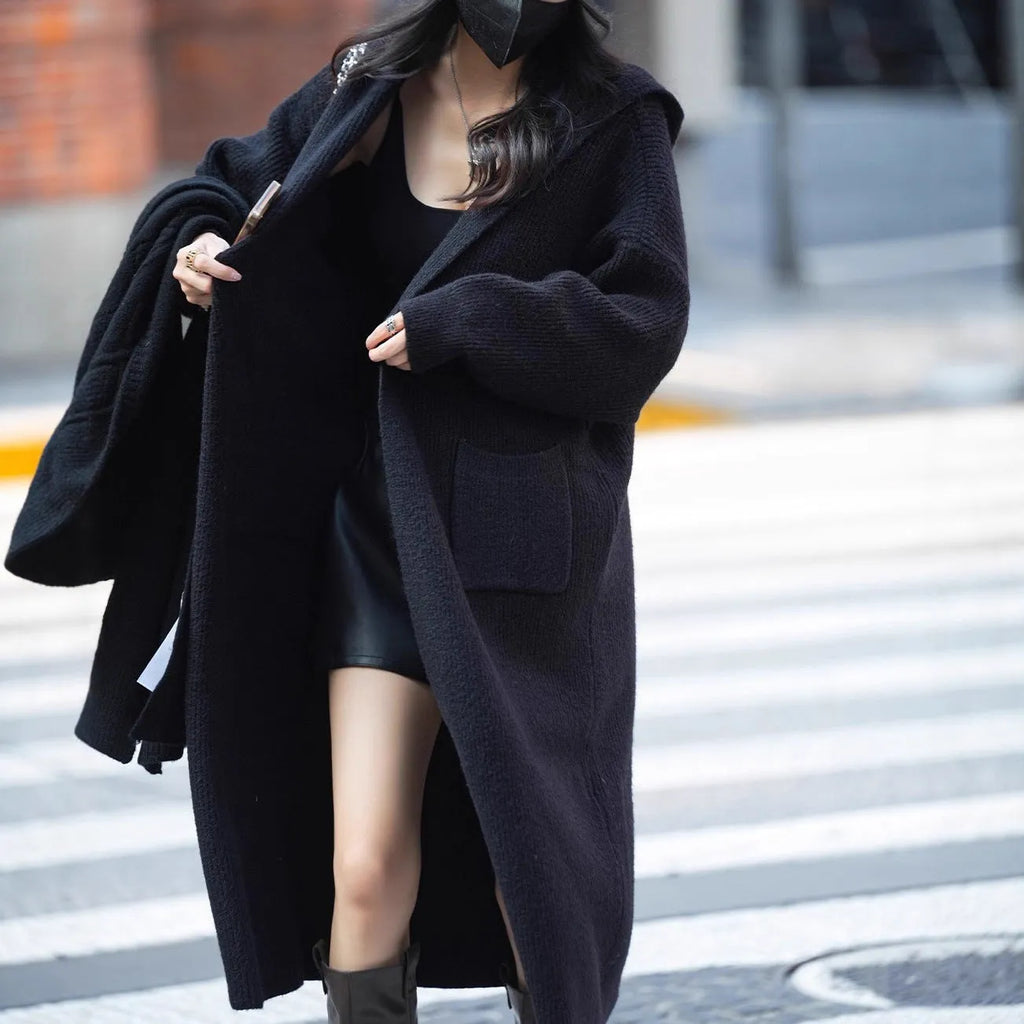 Long grey hooded knitted cardigan with a trench coat style on a hanger