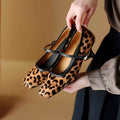 Women's black square toe stiletto ankle-strap shoes with horse hair upper and buckle closure.